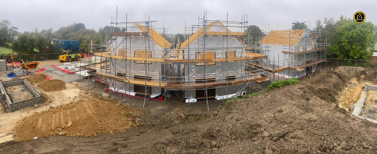 Scaffolded new houses behind open groundworks in Goonhavern